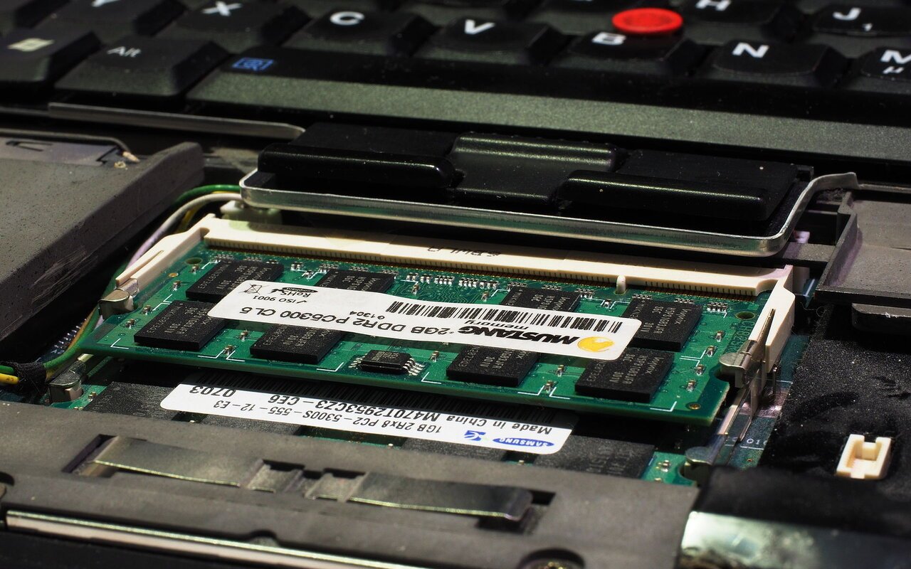Barrette de mémoire SO-DIMM insérée dans le connecteur mémoire d'un ordinateur portable ouvert, sous le clavier
