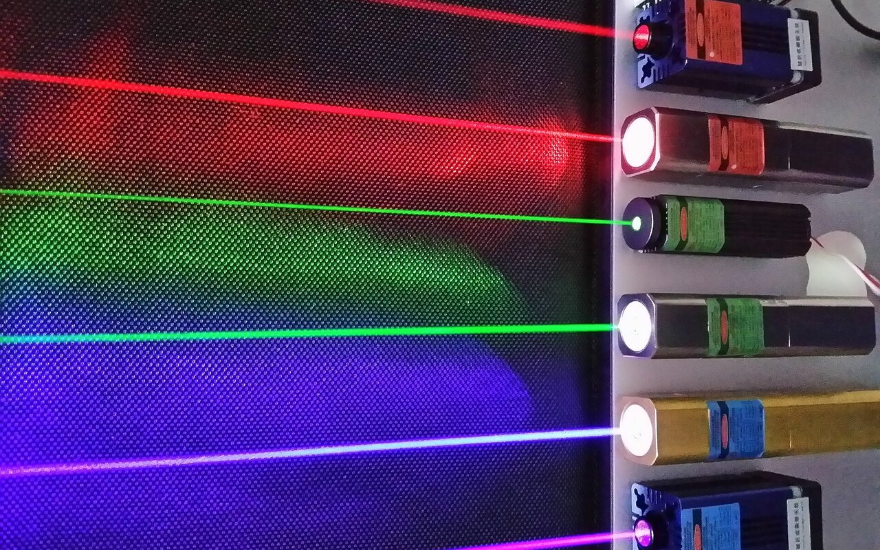 Six lasers commerciaux en fonctionnement produisant des faisceaux de différentes couleurs.