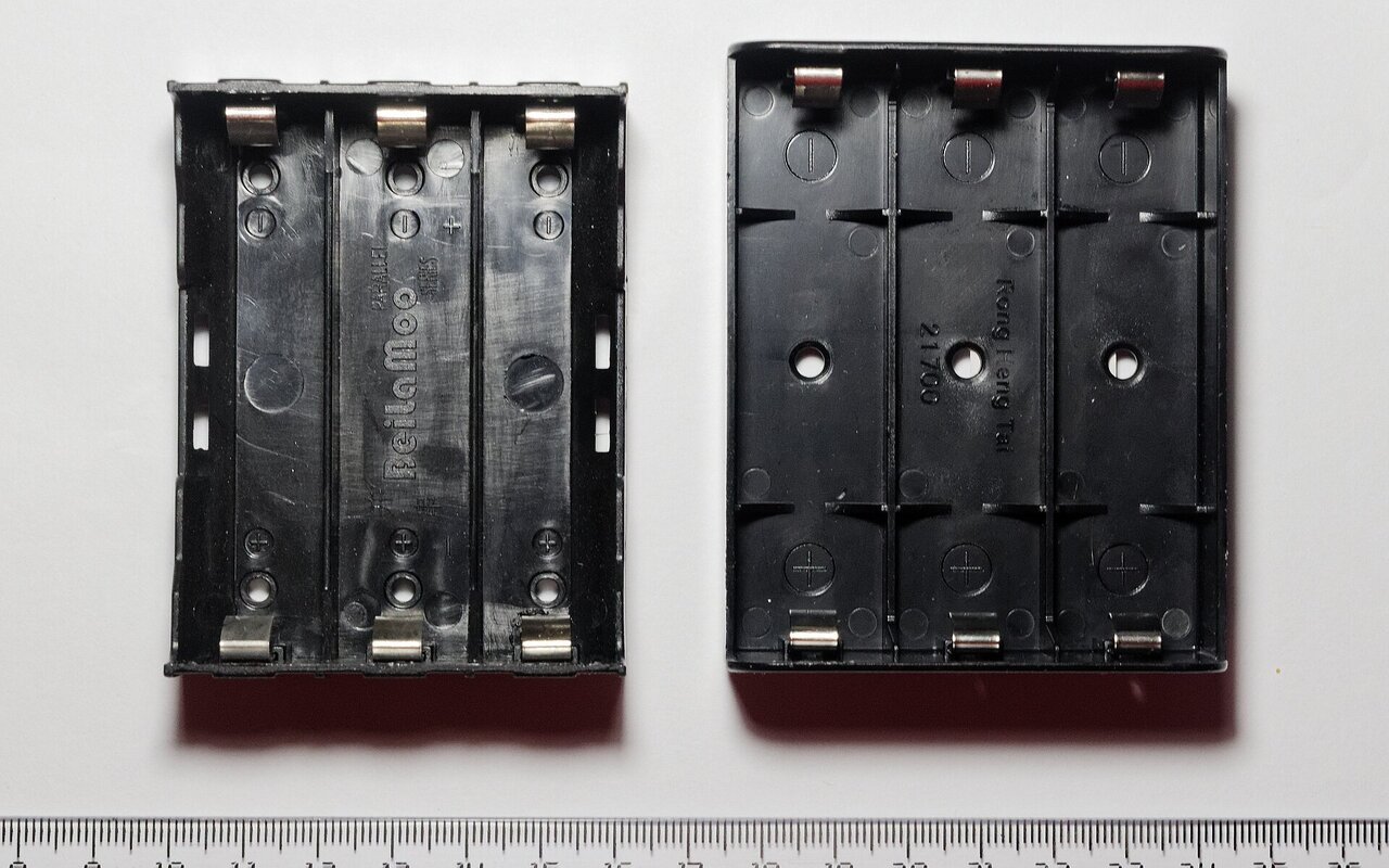 Deux compartiments de batterie côte à côte contenant chacun 3 cellules cylindriques, comparant les tailles 18650 et 21700.