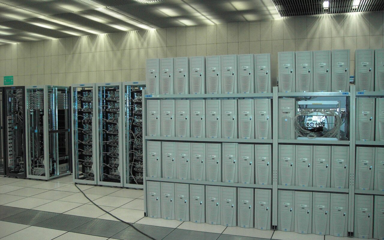 Centre informatique avec des serveurs alignés en racks, illustrant l'infrastructure de calcul