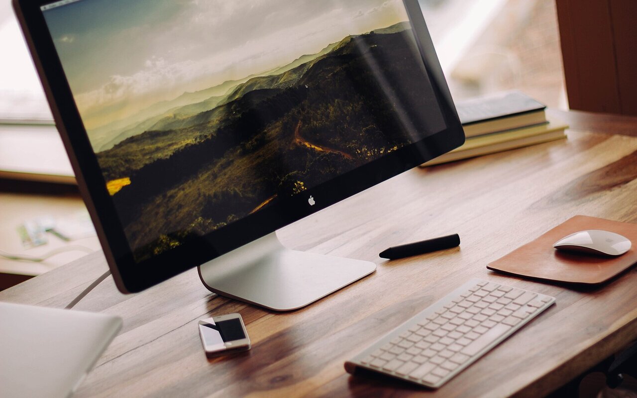 Écran de moniteur Apple affichant l'interface macOS avec ses éléments visuels caractéristiques