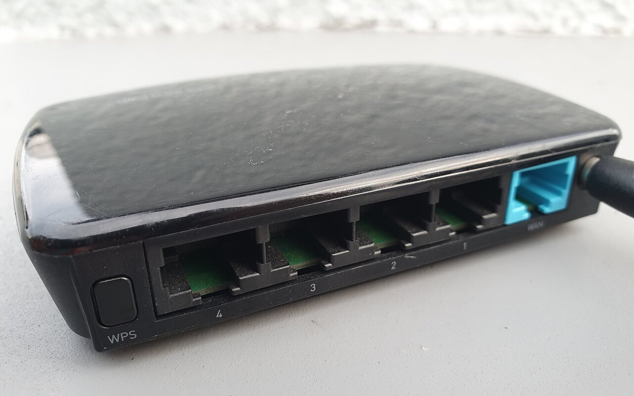 Routeur WiFi ELECOM WRC-300FEBK blanc avec antennes, boutons et voyants lumineux visibles.