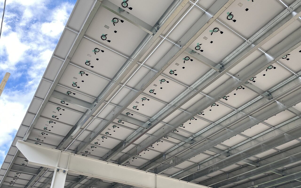Rangées de panneaux solaires installés sur parking en surplomb
