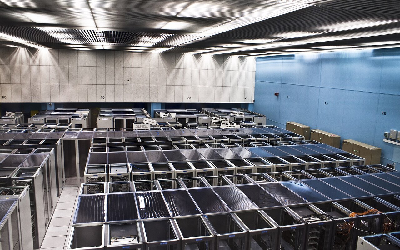 Salle serveur du CERN avec rangées d'équipements informatiques et de câblage réseau organisés verticalement