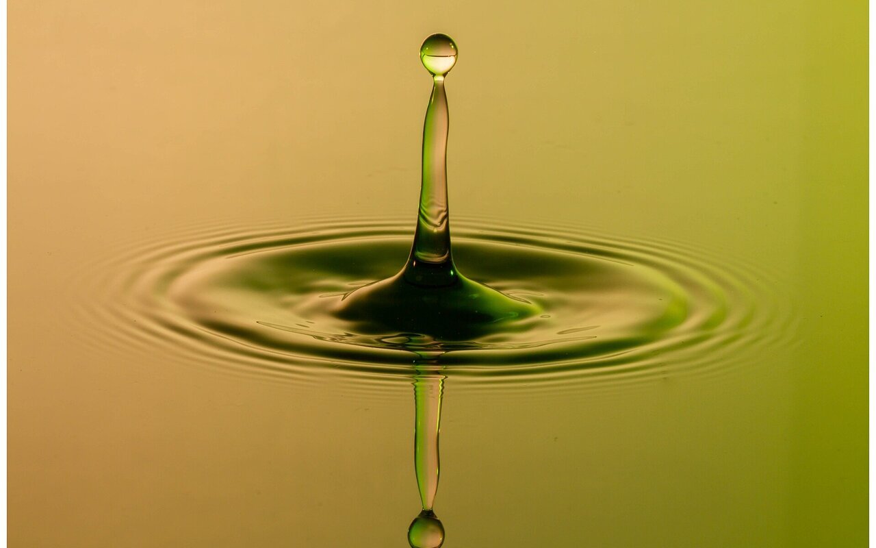 Impact d'une goutte d'eau sur une surface, créant des ondulations et des éclaboussures