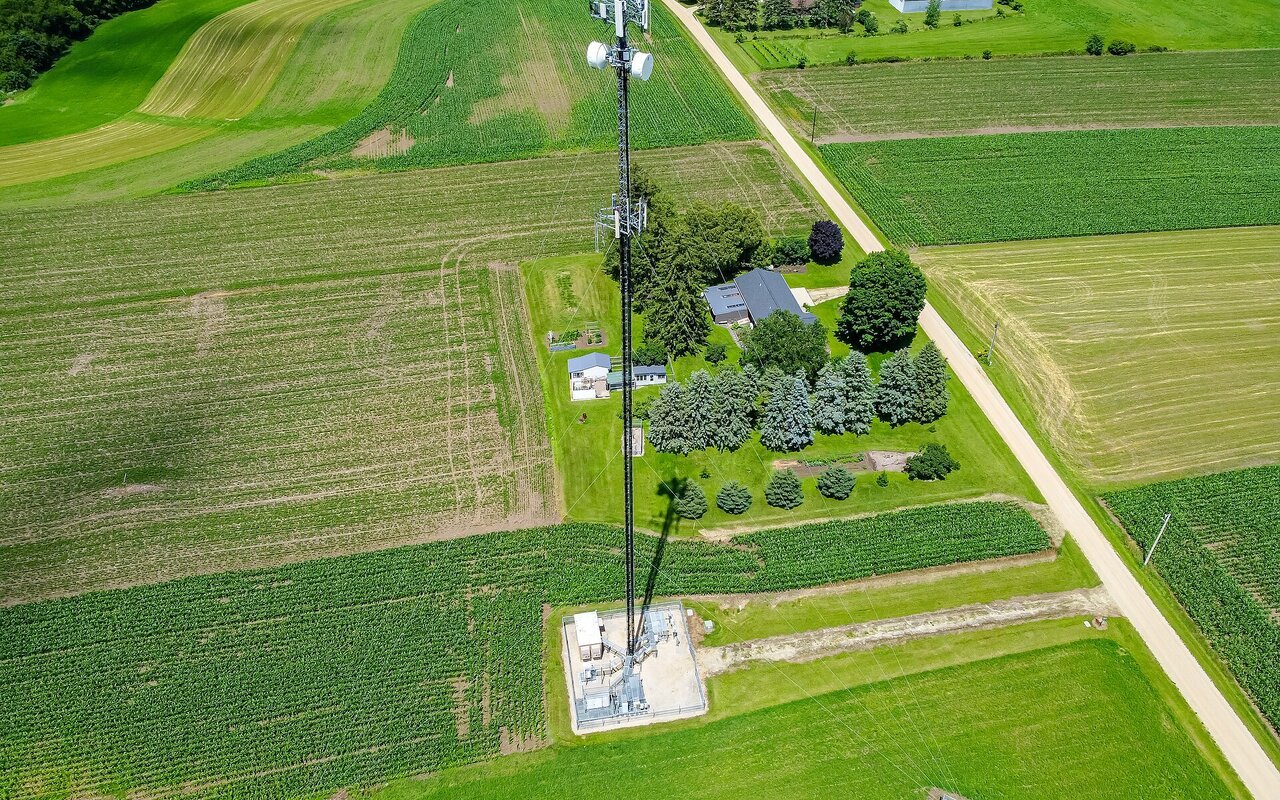 Torre cellulaire métallique rouge et blanche avec antennes, photographiée contre un ciel bleu dégagé en Wisconsin.