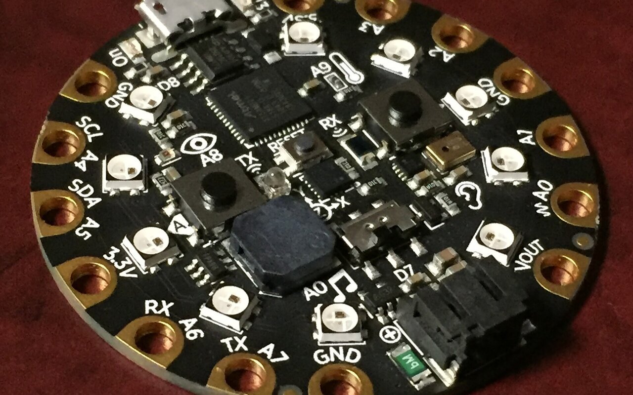 Vue latérale d'une carte Adafruit Circuit Playground Express montrant ses composants électroniques et connecteurs.