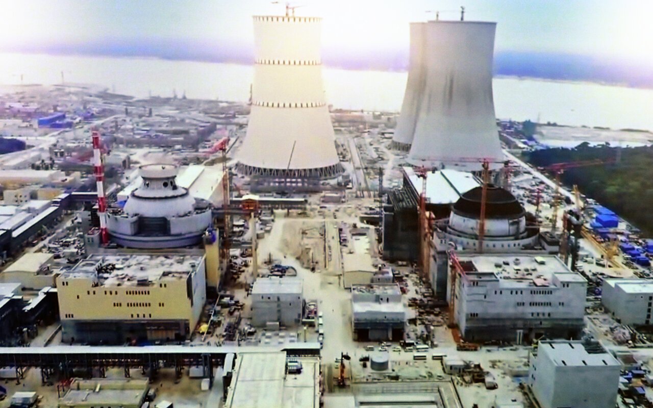 Vue aérienne d'une centrale nucléaire en construction avec structures de béton et installations