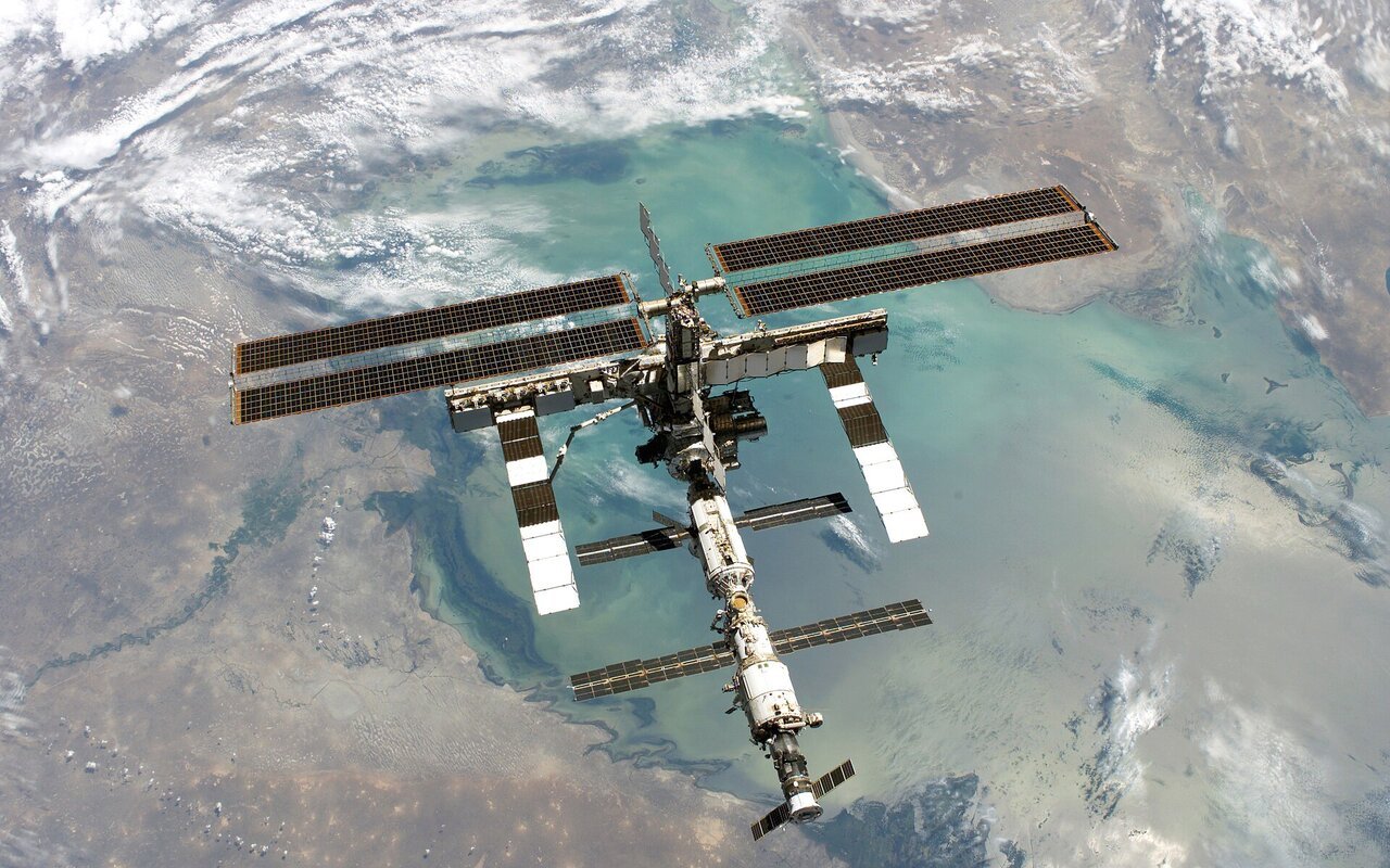 Vue complète de la Station spatiale internationale en orbite avec la Terre en arrière-plan