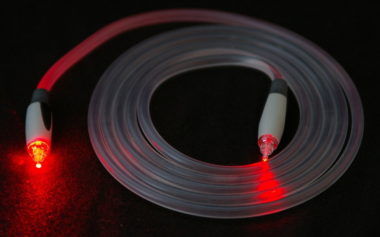 Câble fibre optique illuminé avec un laser rouge visible à travers le connecteur
