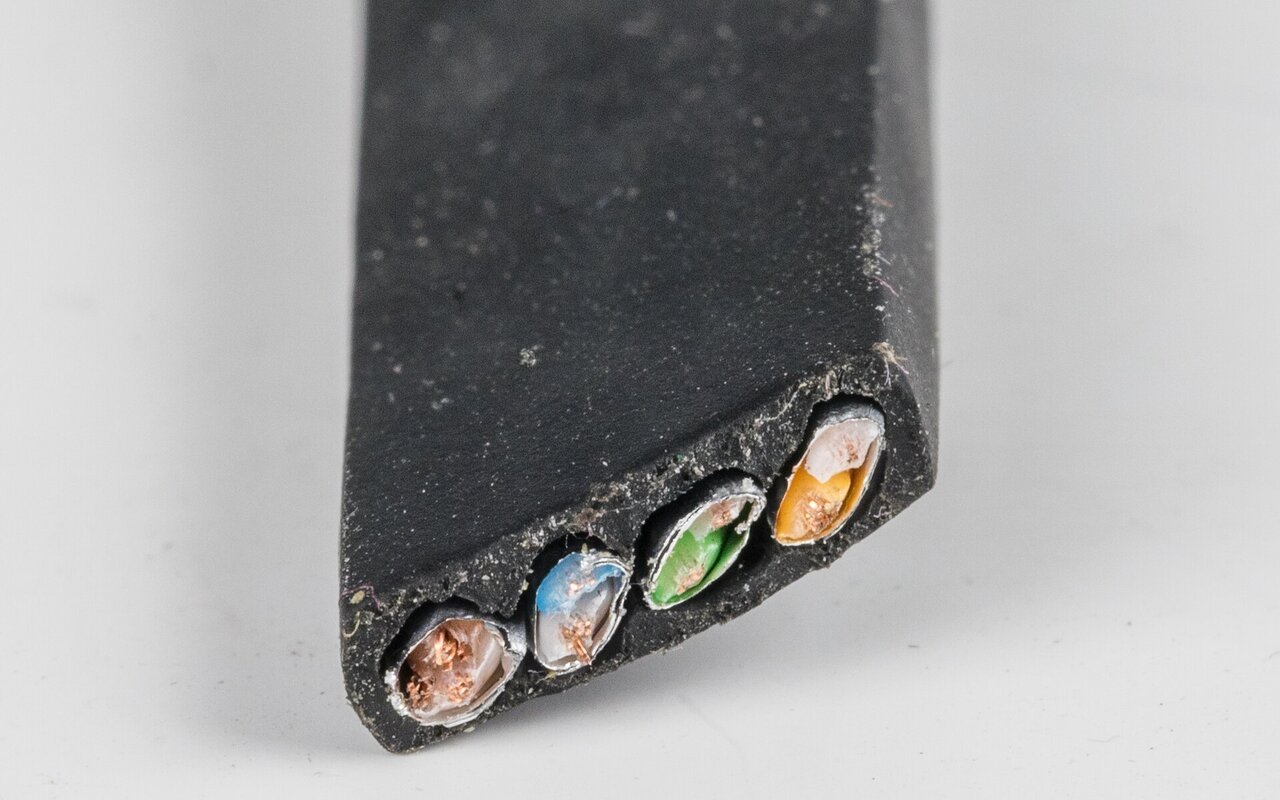 Coupe transversale d'un câble Ethernet CAT8 montrant ses conducteurs de cuivre torsadés et son isolant coloré.