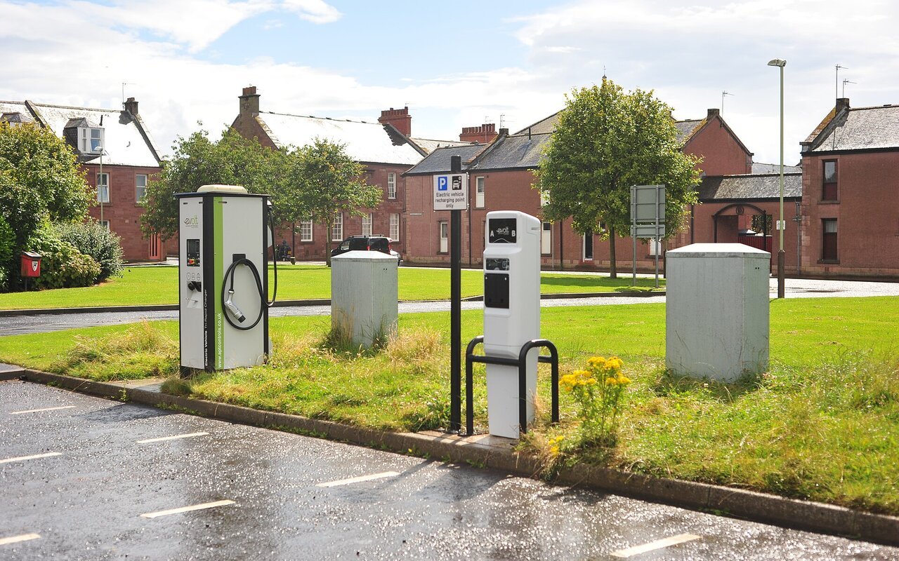 Deux bornes de recharge pour véhicules électriques dans un parking : une Tri-Rapid Compact et une Standard Post