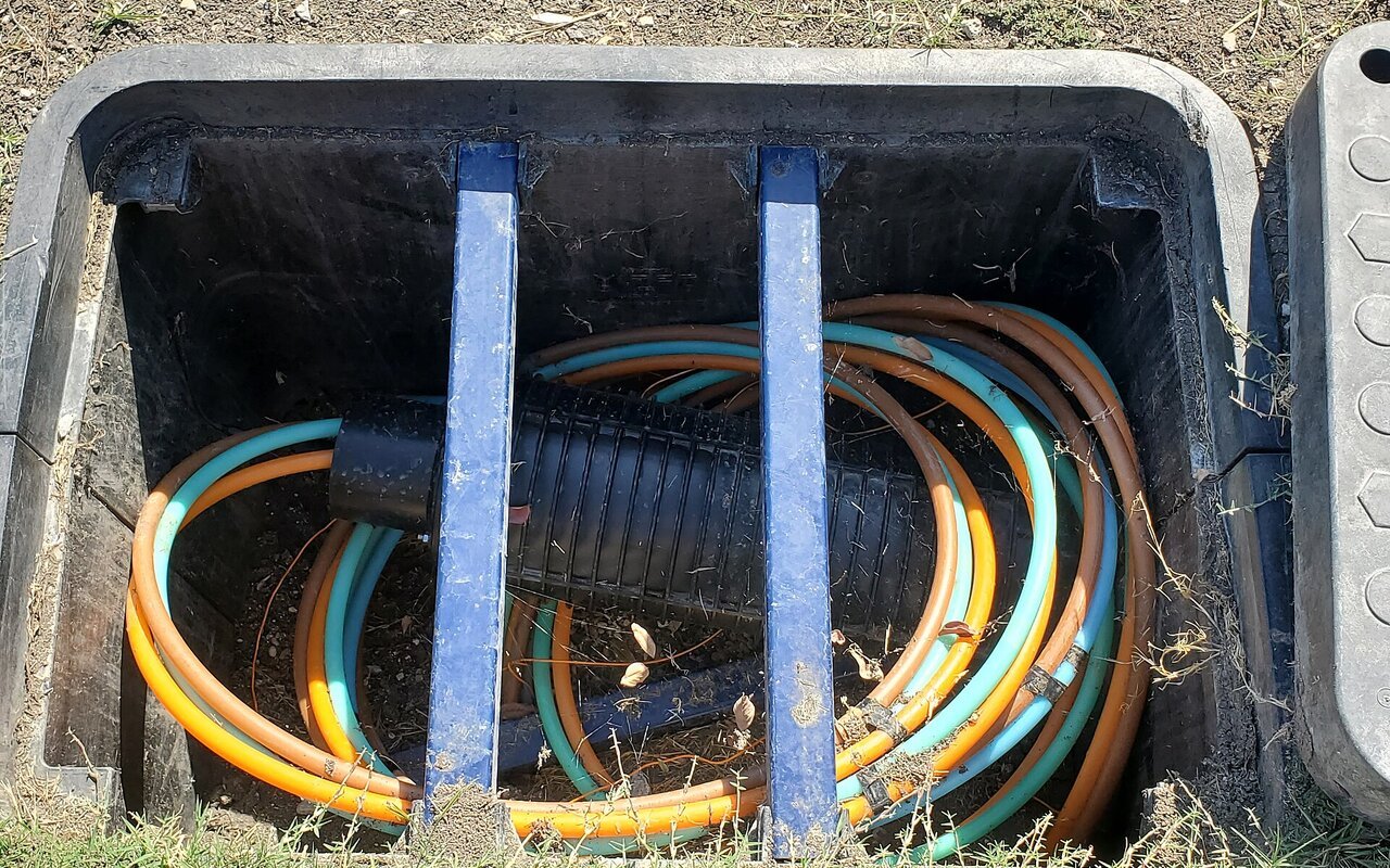 Câble de fibre optique NOVOS enroulé à l'intérieur d'une boîte de raccordement résidentielle