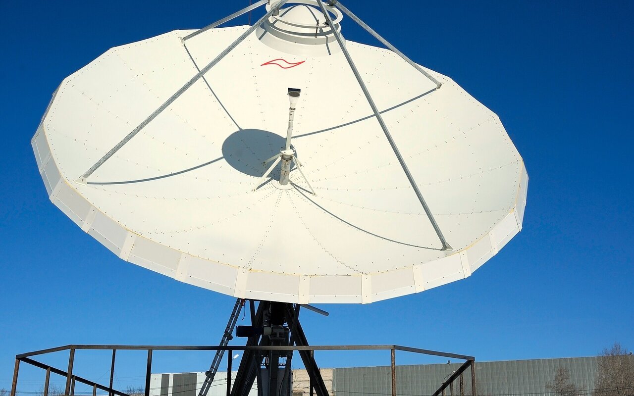 Grande antenne parabolique blanche de 7 mètres de diamètre de marque Andrew, vue de face.
