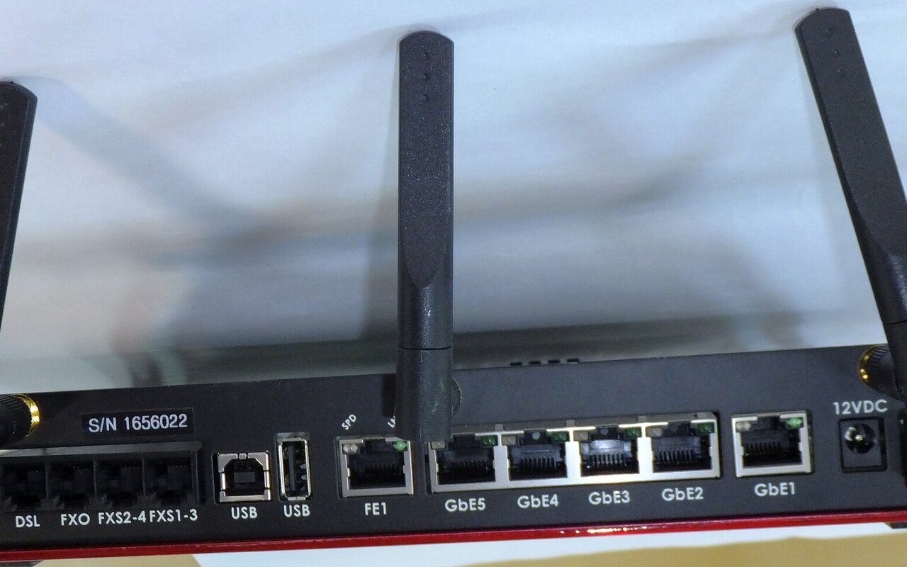 Routeur WiFi Broadcom blanc et noir avec antennes externes, ports de connexion visibles sur le panneau arrière