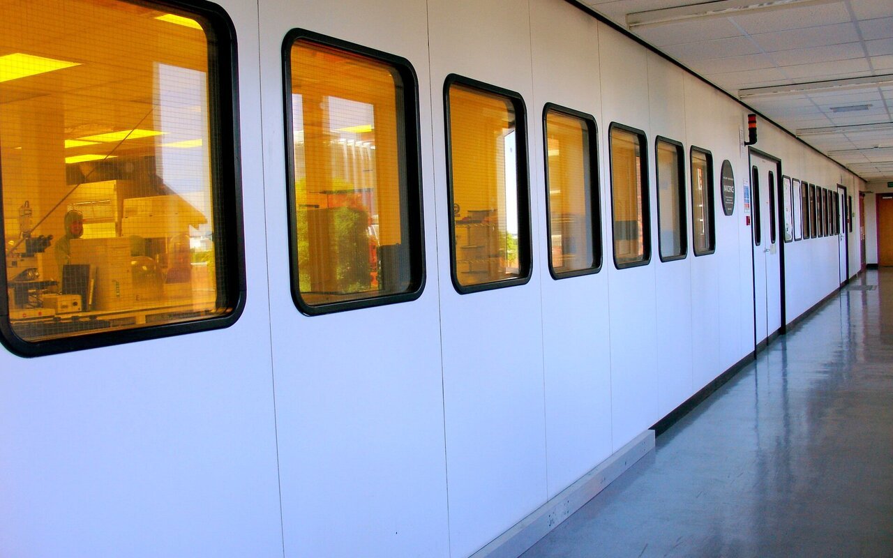Vue extérieure d'une salle blanche avec portes d'accès et signalisation de contrôle d'environnement