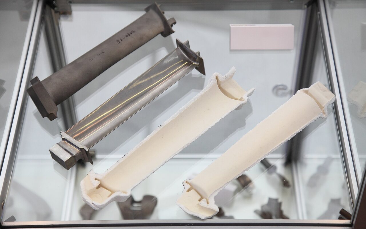 Ensemble de pales de turbine montrant le moule céramique, la pale brute et la pale polie