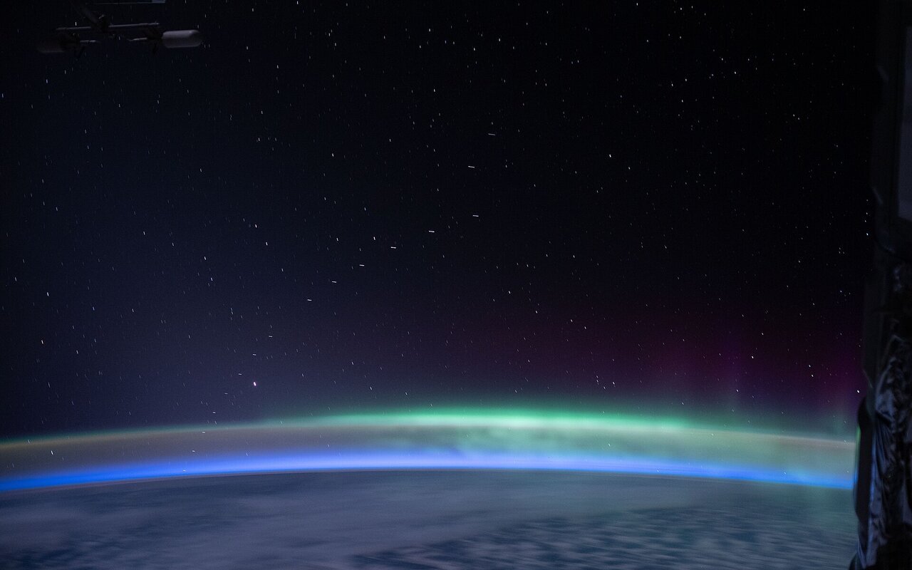 Vue de la Terre depuis l'ISS avec la constellation de satellites Starlink en arrière-plan
