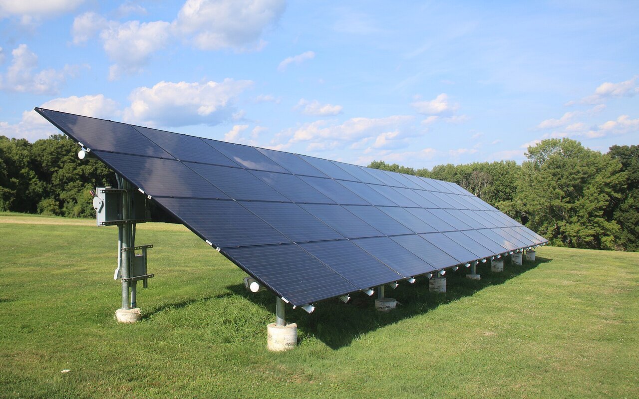 Panneaux solaires au sol installés dans un champ, technologie photovoltaïque standard.
