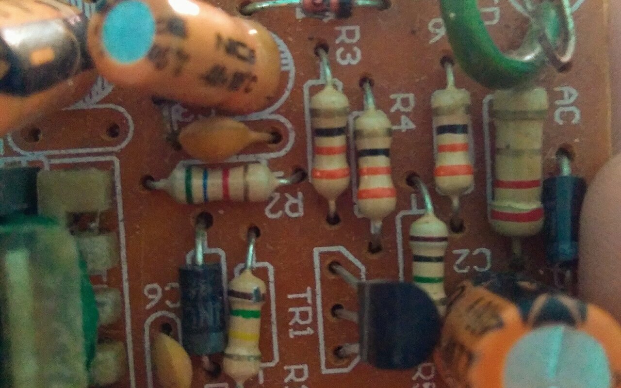 Composants électroniques variés sur circuit imprimé incluant résistances, transistors, capacités et diodes