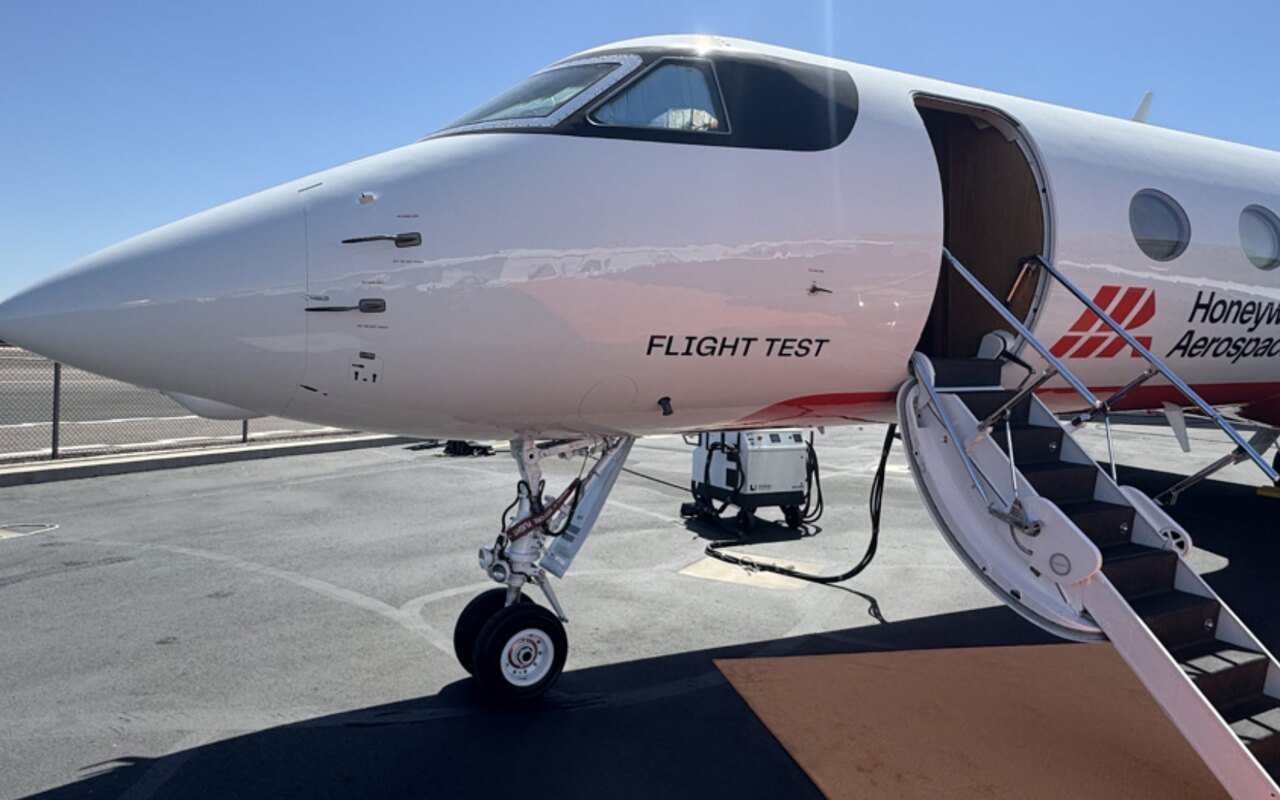 Techniciens autour d'un prototype MagNav près d'un Embraer 170