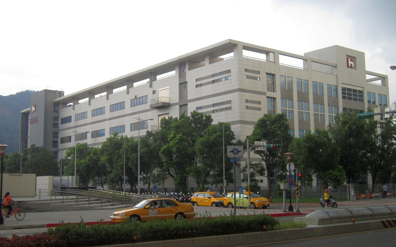 Façade de l'usine Dingpu de Hon Hai Precision Industry à Taïwan, bâtiment blanc de plusieurs étages vu depuis la rue