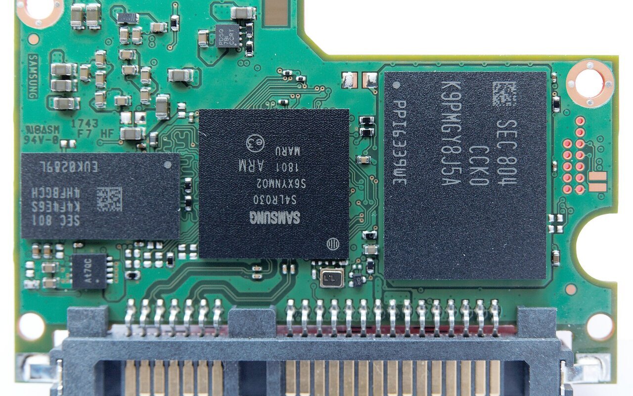 Circuit imprimé interne d'un SSD Samsung 860 Pro montrant plusieurs boîtiers de mémoire flash NAND et le contrôleur, avec le connecteur SATA