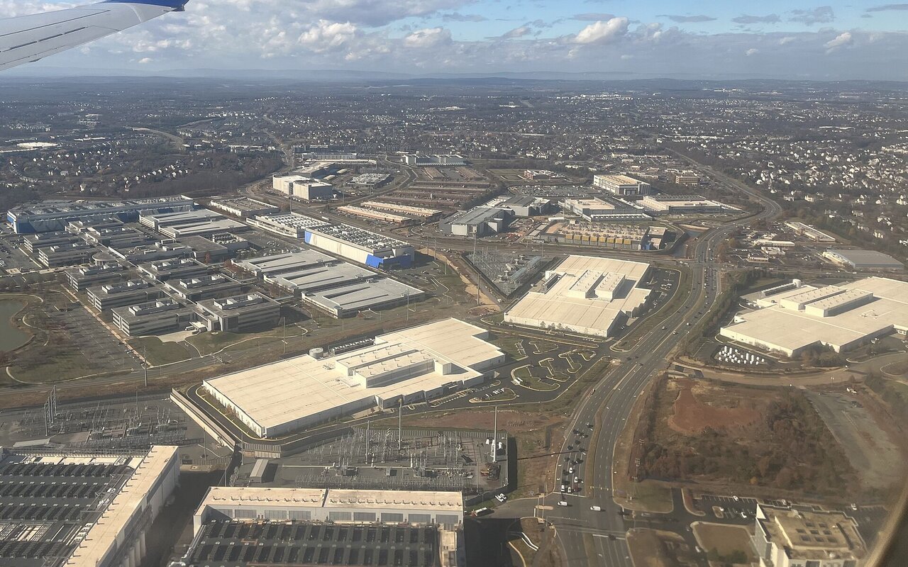 Vue aérienne d'un ensemble de bâtiments de data centers aux toits plats et de leurs parkings, à Ashburn, en Virginie