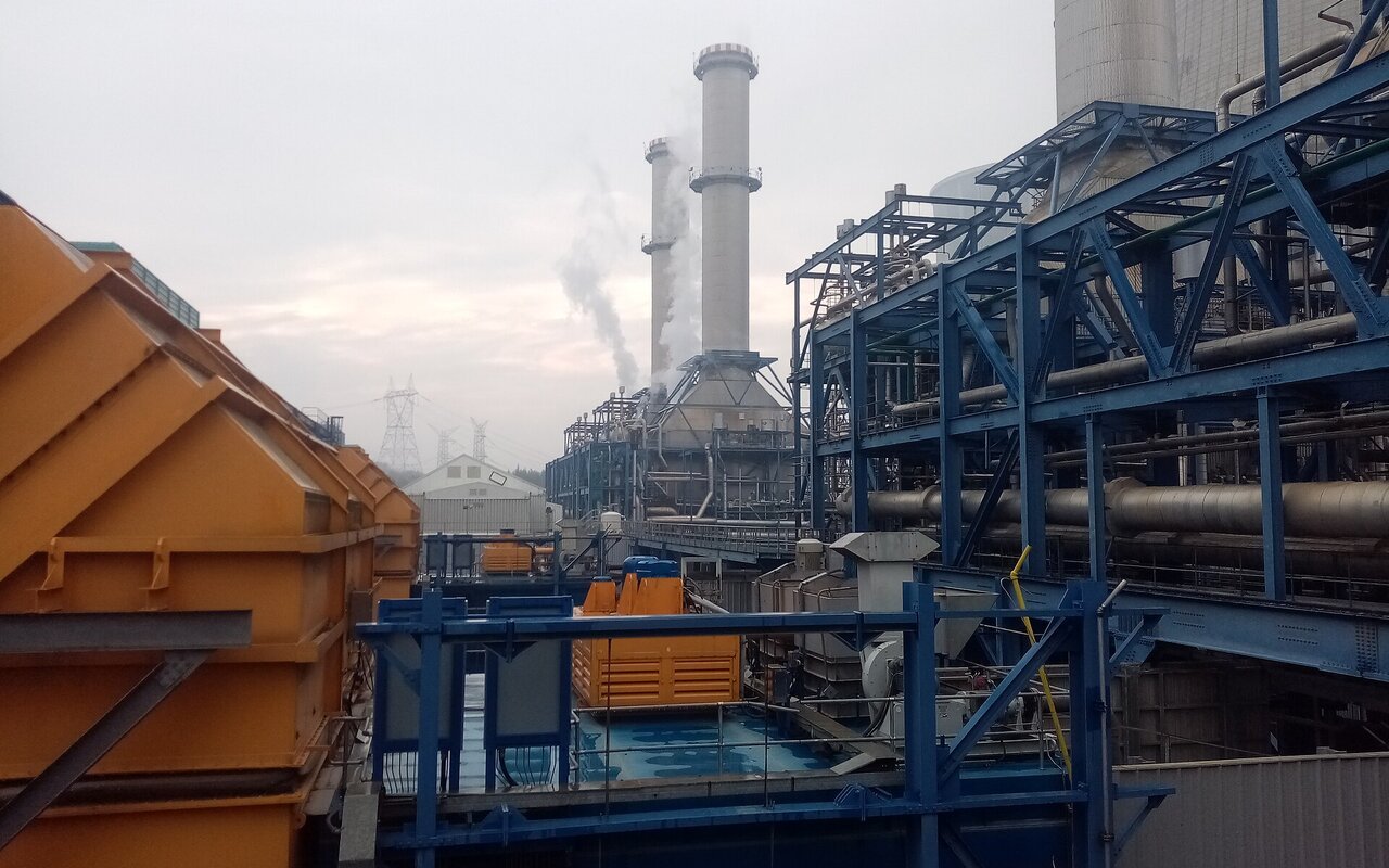 Cheminées et structures métalliques d'une centrale électrique à gaz à cycle combiné, avec des panaches de vapeur au-dessus des installations
