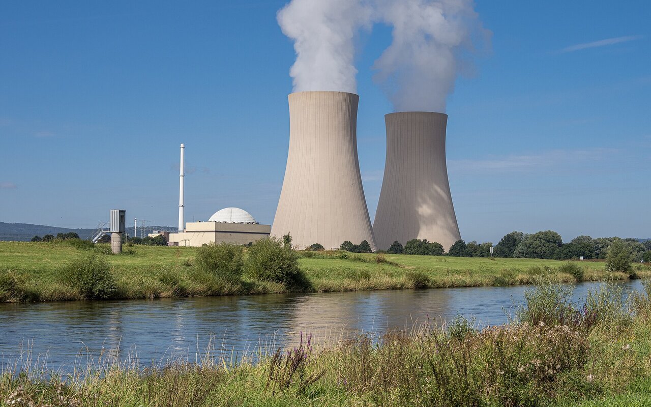 Les deux tours de refroidissement et le dôme du réacteur de la centrale nucléaire de Grohnde vus depuis la rive de la Weser, un panache de vapeur au-dessus des tours